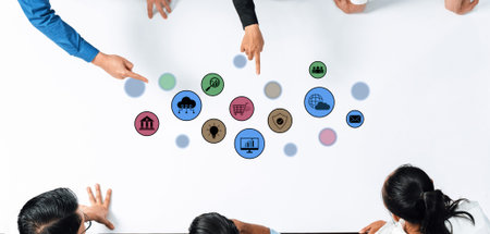 A diverse group of professionals engages in a brainstorming session over a white table, using...
