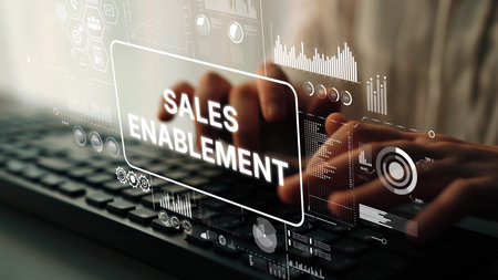 Hands Typing on Keyboard with Sales Enablement Graphics and Data Visualizations in a Modern Office...