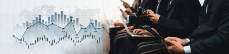 Business professionals engage in financial analysis using digital devices in a corporate...