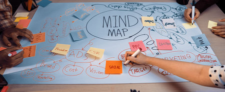 Creative brainstorming session featuring diverse hands working together on a large mind map with colorful sticky notes, fostering collaboration and innovative thinking.の写真素材