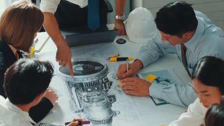 Group of diverse team planning strategy while sitting at table with project plan. Top aerial view of...