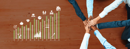 Hands Joining Together on a Wooden Table with Business Graph and Icons Representing Growth, Success,...
