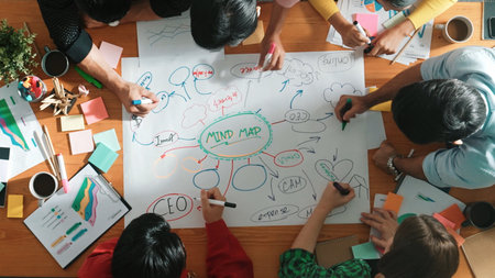 Group of business people writing and making mind map to brainstorming marketing idea at meeting. Top...