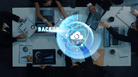 A business team collaborates in a modern office, focusing on data backup strategies using cloud...