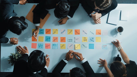 Smart cooperate business people writing and brainstorming business idea by using sticky notes. Top...