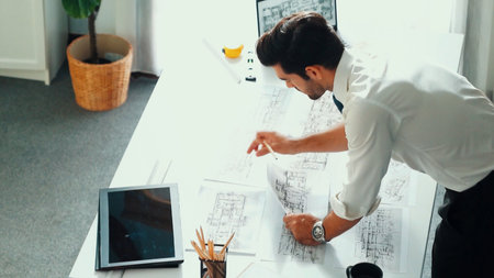 Architect engineer using laptop planning house design at office while sitting at meeting table with...
