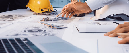 An engineering team collaborates on detailed technical drawings in a modern office space....