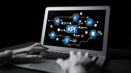 A robotic hand reaches for a laptop, featuring a vibrant display of key performance indicators,...