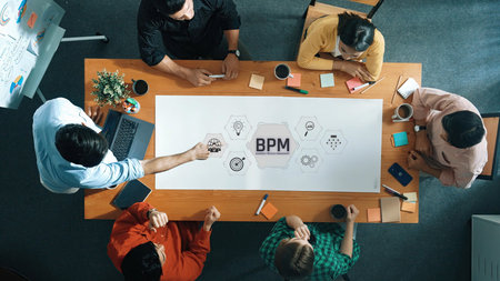 A diverse group of professionals engages in a collaborative meeting focused on business process...