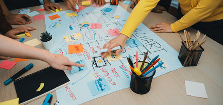 A vibrant scene of teamwork with diverse hands engaged in creating a mind map using sticky notes and...