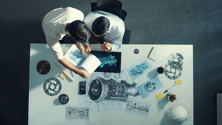 Top down aerial view of manager sitting while answering questions about jet engine. Professional...