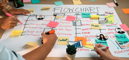 A lively workspace features hands creating a flowchart with vibrant sticky notes and markers,...