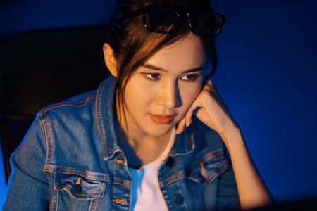 Stressful young beautiful asian creative looking on pc to search project creator social media online...