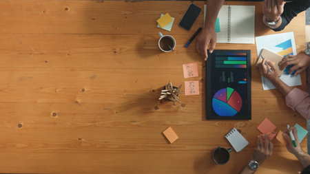 Top aerial view of diverse team writing colorful sticky notes to brainstorm marketing idea....