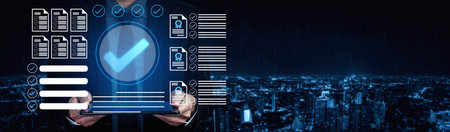 A businessman stands in front of a city skyline at night, utilizing advanced digital technology for...