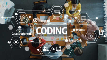 A top view of a diverse team collaborating on coding and software development in a modern workspace,...
