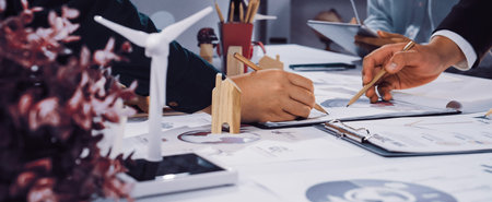 Team members engage in collaborative brainstorming on sustainable energy concepts while exploring innovative designs for eco-friendly solutions in a modern workspace.の写真素材