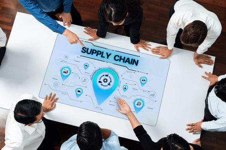 A group of professionals engage in a collaborative meeting around a digital interface showing supply...