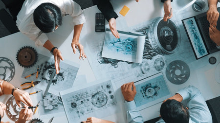 Top down aerial view of smart engineer team working together to design turbine engine. Professional...