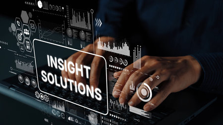 Business professional working on laptop with digital graphics representing data analysis and insight...
