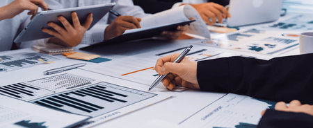 A dynamic meeting scene showing professionals engaged in discussion, analyzing charts and graphs...