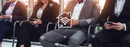 A group of professionals engaged in a business meeting, using smartphones while symbolizing...
