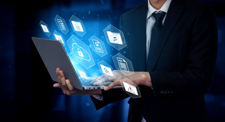 Businessman uses laptop to showcase concepts of cloud technology and data security, highlighted by...
