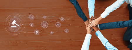 Hands of diverse individuals stack together symbolizing teamwork and collaboration in a legal...