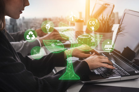Business Professional Working on Laptop with Eco-Friendly Graphics in Modern Office Environment,...