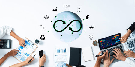 A top-down view of a diverse business team engaging in discussions on sustainability strategies,...