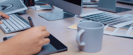 A professional creative workspace featuring a laptop, color palettes, and stationery, ideal for...