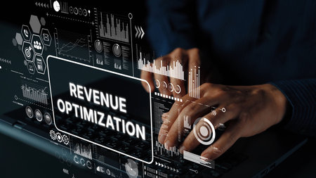 Hands Typing on Laptop with Revenue Optimization Concept and Data Analytics Graphics in Background....