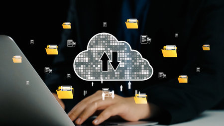 Illustration of hands working on a laptop with cloud computing icons, showcasing file upload and...