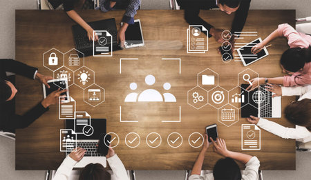 A diverse team collaborates in a modern office setting using laptops and notebooks for effective...