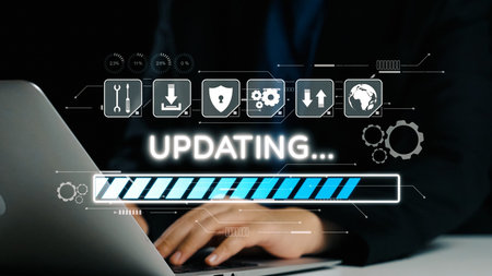 A close-up view of hands on a laptop keyboard during a software update, showcasing a loading...