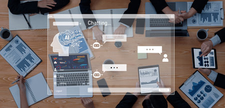 A high-angle view of a business meeting showcasing a laptop with an AI chat interface. Participants...