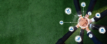 Aerial view of diverse business professionals joining hands on green grass, symbolizing...