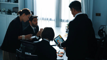 Top view of professional business people looking at financial chart from tablet while diverse group...