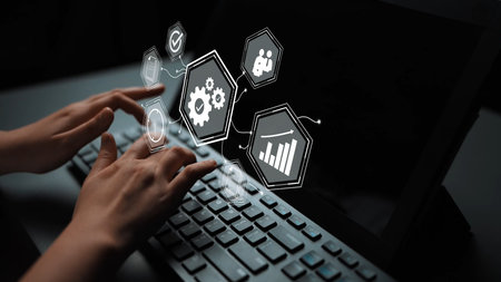 Hands Typing on Keyboard with Graphic Icons Representing Data Analysis, Automation, and Technology...