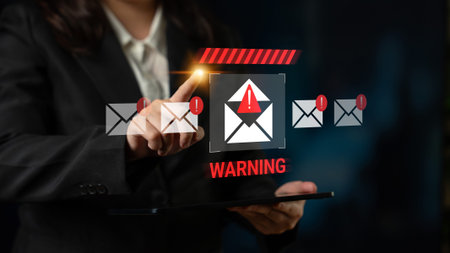 A business professional interacts with a digital warning indicator about email threats, highlighting...