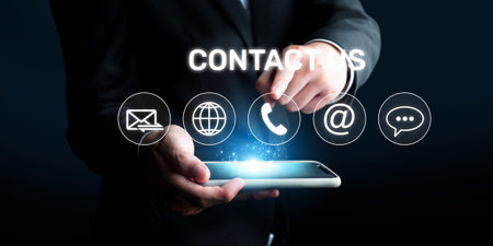A businessman engages with advanced technology, showcasing contact icons for efficient online...