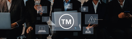 A group of business professionals engaged in a technology discussion with laptops and smartphones,...
