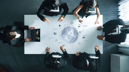 A business team engages in a high-tech meeting using virtual reality to explore global data and...
