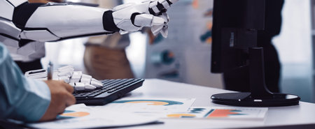 A robotic hand pointing at a computer screen, showcasing business charts and data analysis in a...