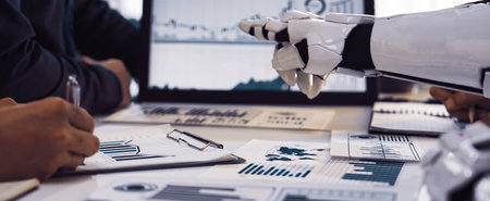 A robot collaborates with humans in a modern office, focusing on data analysis. Graphical...
