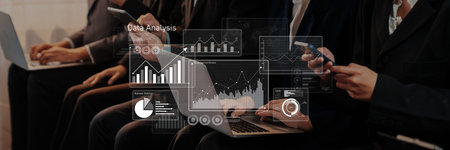 Business professionals engage in a data analysis session, utilizing laptops and smartphones to...