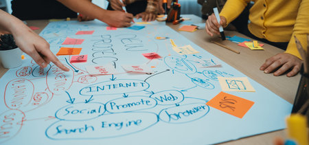 A diverse group of individuals collaborates on an internet project using colorful sticky notes and...