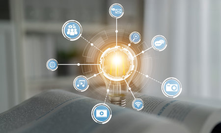 A creative representation of a light bulb surrounded by digital icons symbolizes the connection between technology, communication, and knowledge, inspiring innovation. Cruxの写真素材