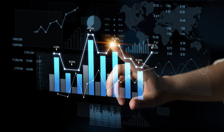 A close-up view of a hand interacting with digital graphs and data visualizations, showcasing financial trends and global market analysis in a modern technology setting.の写真素材