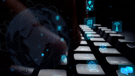 A close-up image portraying hands on a keyboard with illuminated global connectivity icons, symbolizing technology and communication in a modern digital world.の写真素材
